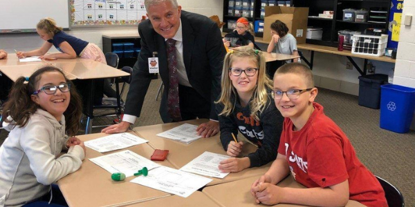 Minster Bank President Dale Luebke with students during financial literacy program