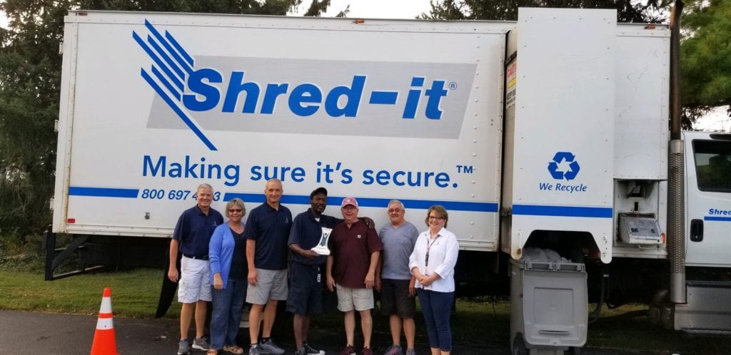Minster Bank employees at Minster Bank Community Shred Event to securely dispose of documents for identity theft prevention.